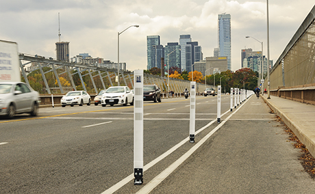 Protected bike lane on a bridge with flexible bollard delineator post - City of Toronto, ON