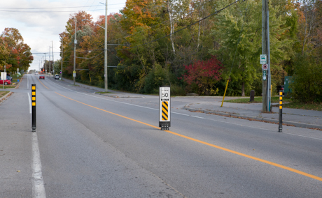 Traffic calming measure with flexible sign and bollards - Municipality of Clarington