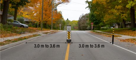 Traffic calming with flexible sign and flexible bollardon a Two-way street with a width of 9 metres and a parking lane