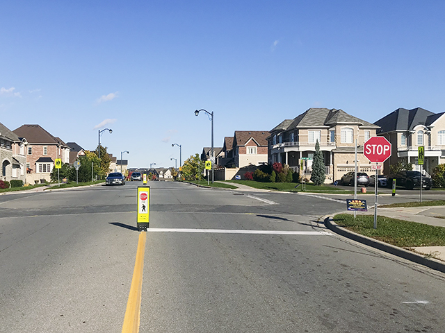 Pedestrian crossing sign at an intersection controlled with stop signs - City of Vaughan, ON