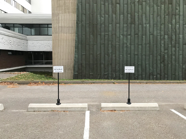 Poteau de stationnement flexible avec affiche réservé sur butée de béton