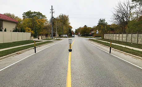 Traffic calming collector road with flexible signs / bollards